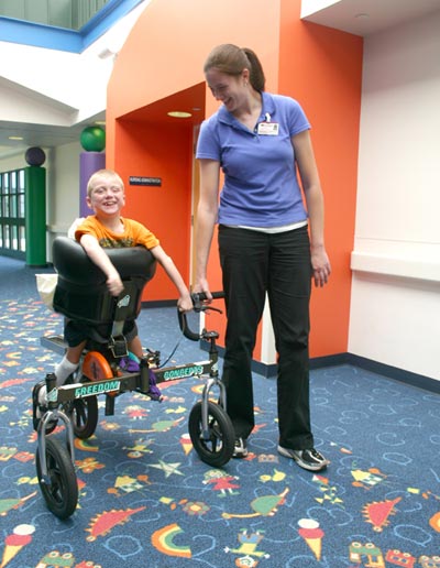 Jennifer Savage, a physical therapy doctoral student from Elon University in Elon, North Carolina, gives some guidance to seven-year-old Bryce Ros