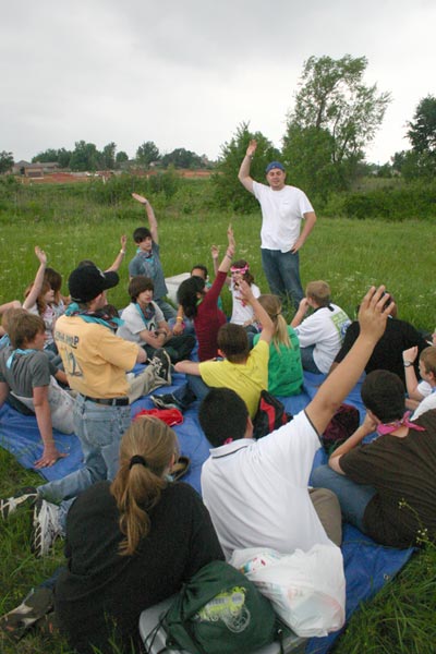 Brent Hodges, Whittier Middle School special education teacher and girl's basketball coach, asks for a show of hands as he leads a discussion about the trust walk experience. The trust walk was just one of several activities that eighth graders participated in during Whittier's annual WOW week. The trust walk was conducted on the J. D. McCarty Center campus when the May 10 tornado closed down Lake Thunderbird, the original location for this event.