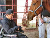 Image of a Young Man Smiling next to a Horse